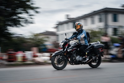 man in black helmet riding motorcycle on road during daytime
